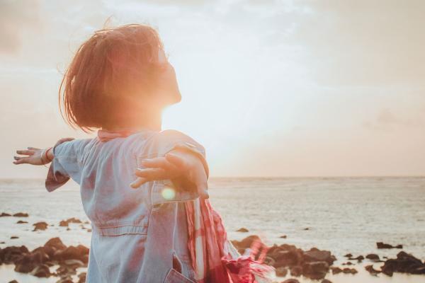 woman opening arms to light